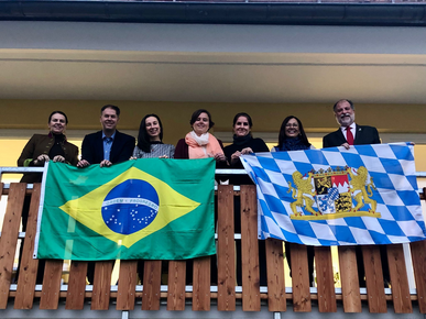 Gruppe von Menschen mit der bralisianischen und bayrischen Flagge