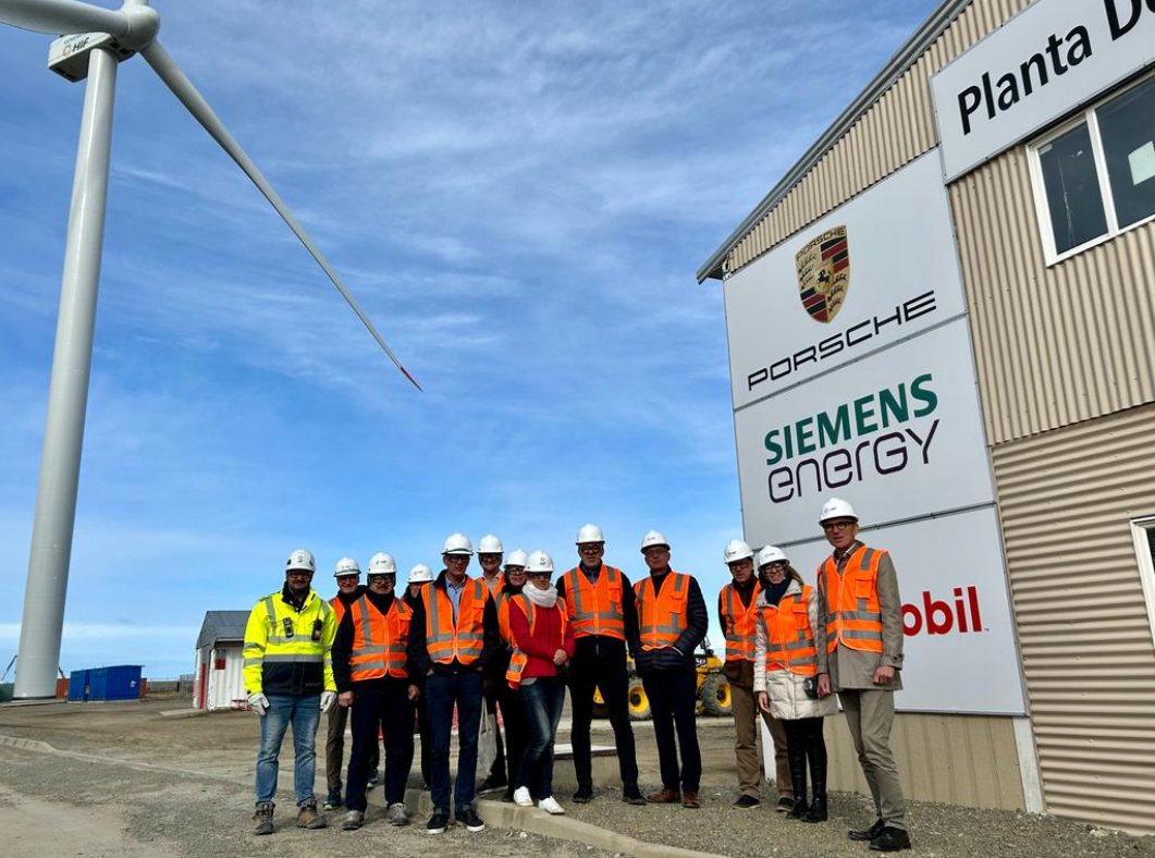 Gruppenfoto der DelegationsteilnehmerInnen. 20 Personen stehen in weissen Helmen und in Warnwesten vor einem Gebäude. 